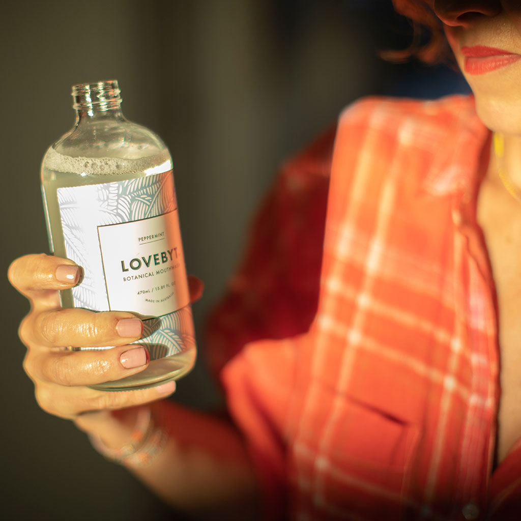 Amy holding a bottle of LOVEYBYT Mouthwash